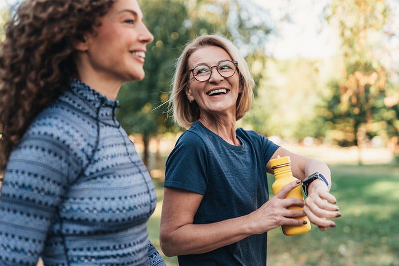 Two women walking outside for exercise on a sunny day
