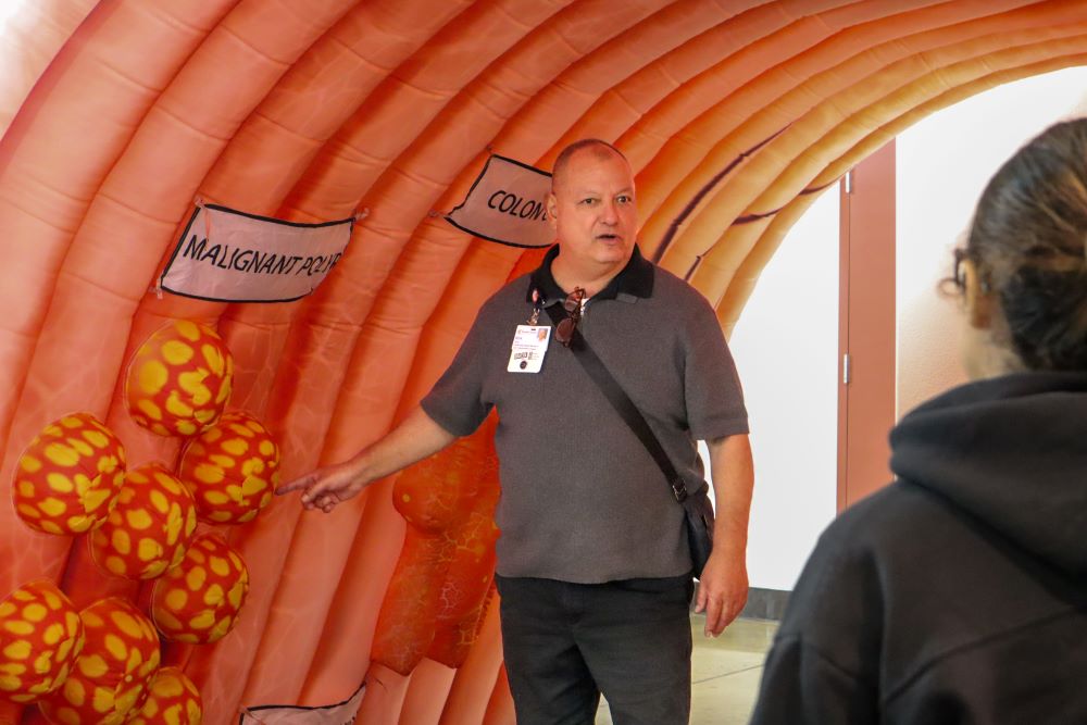 person standing in front of blow up colon demonstration