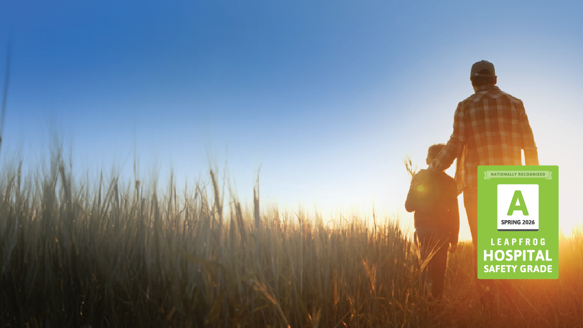 Farmer and child standing in a field with A grade from Leapfrog.